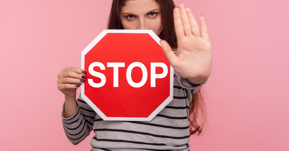 Frau hält ein Stopschild in der Hand